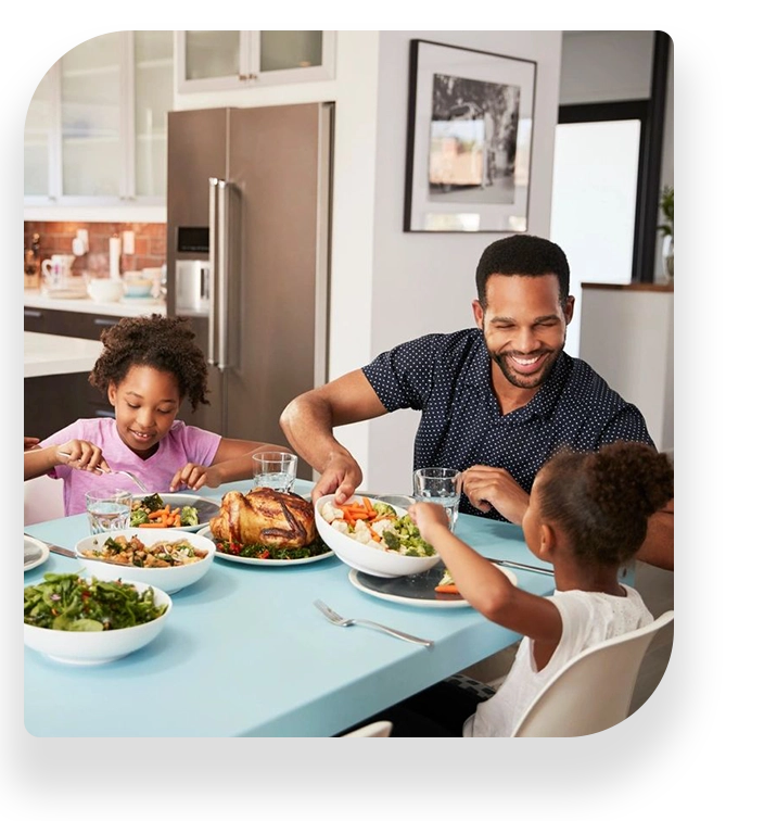 A man and two children sitting at the table eating.