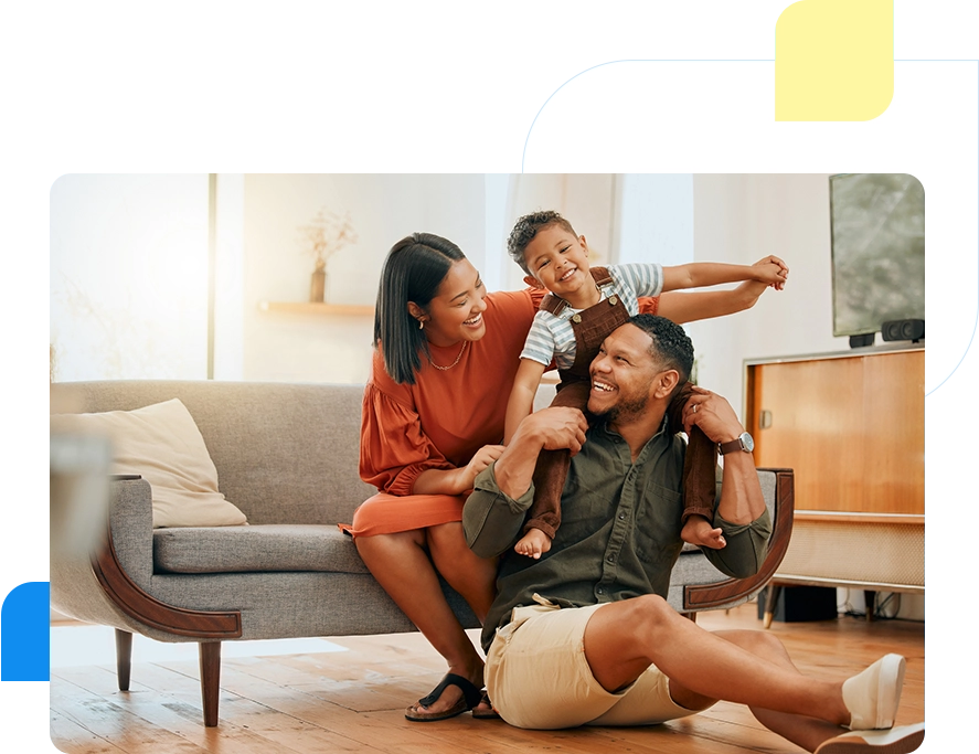 A family sitting on the ground in front of a couch.