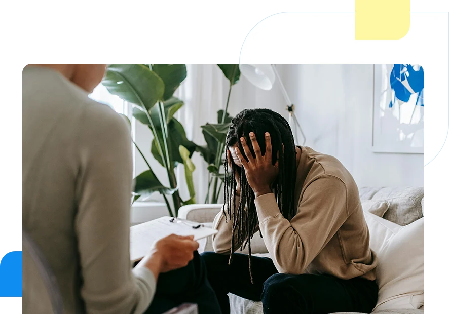 A woman sitting on the couch with another person.