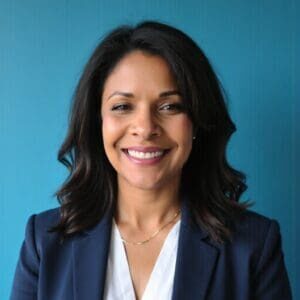 A woman in a suit smiling for the camera.