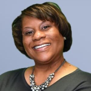 Smiling woman with short hair and a necklace.